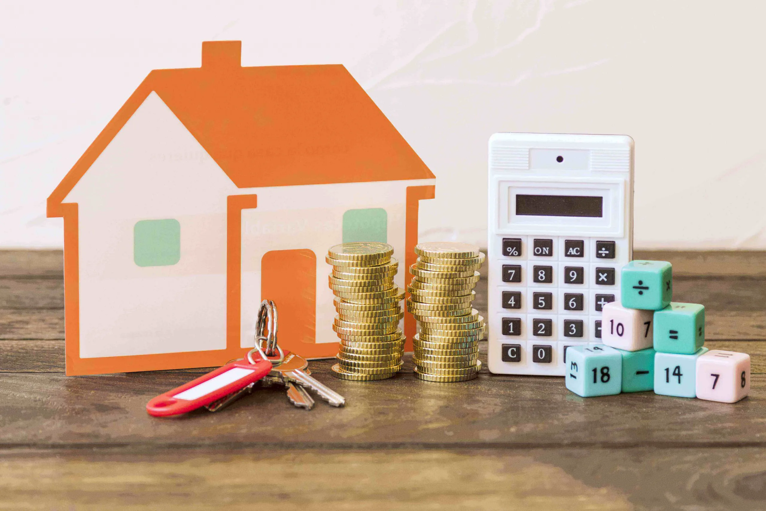 house key stacked coins calculator math blocks wooden table min 1 scaled 1 jpg